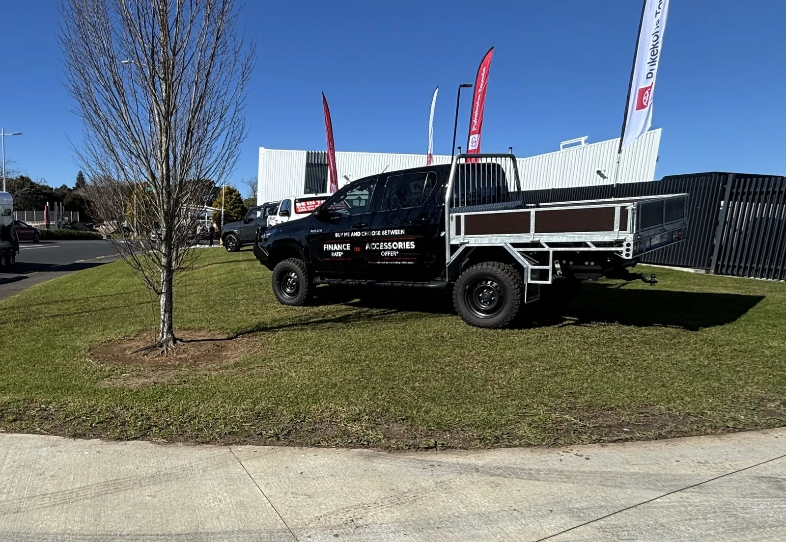 The Underground Gardening truck parked on a freshly mown island at a car dealership