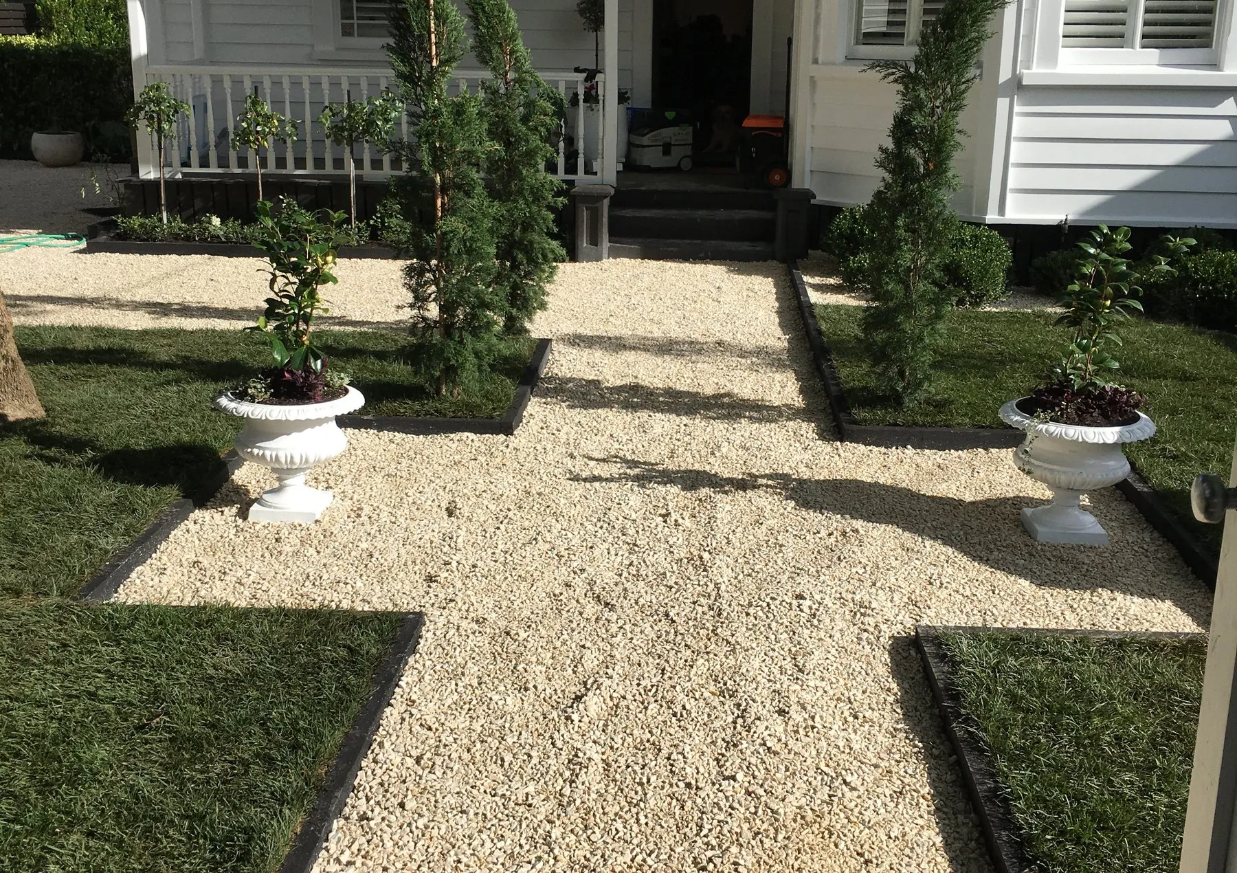 Gravel courtyard with topiary and urns